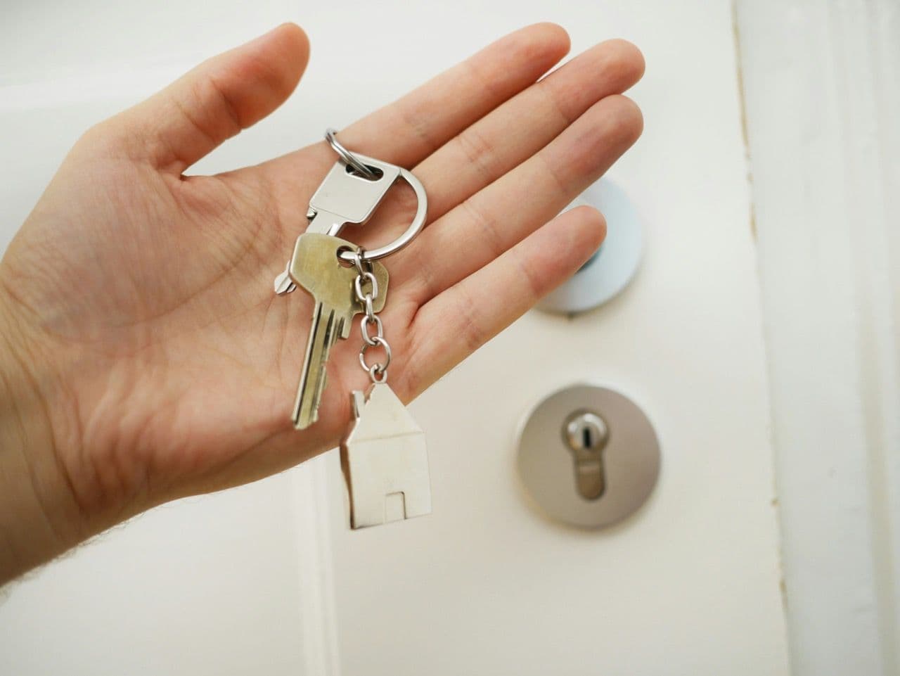 a hand with keys, a lock